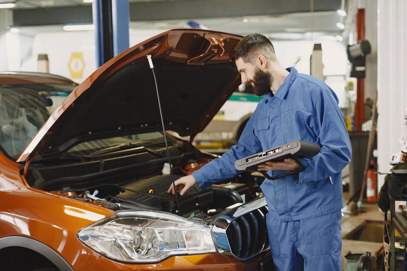 Mechanic inspecting a vehicle engine in a workshop