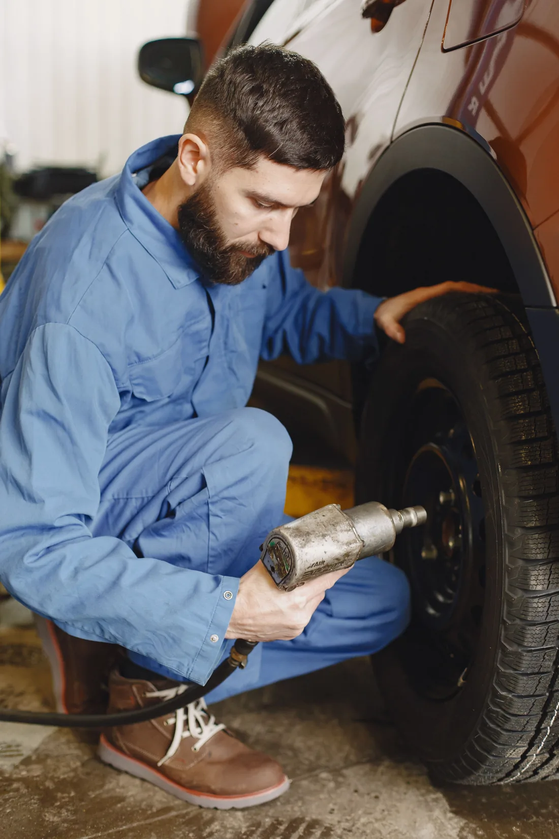 Mechanic working on a vehicle wheel and tyre